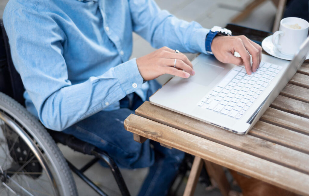User interacting with accessible digital devices, including a screen reader, braille display, and voice commands.