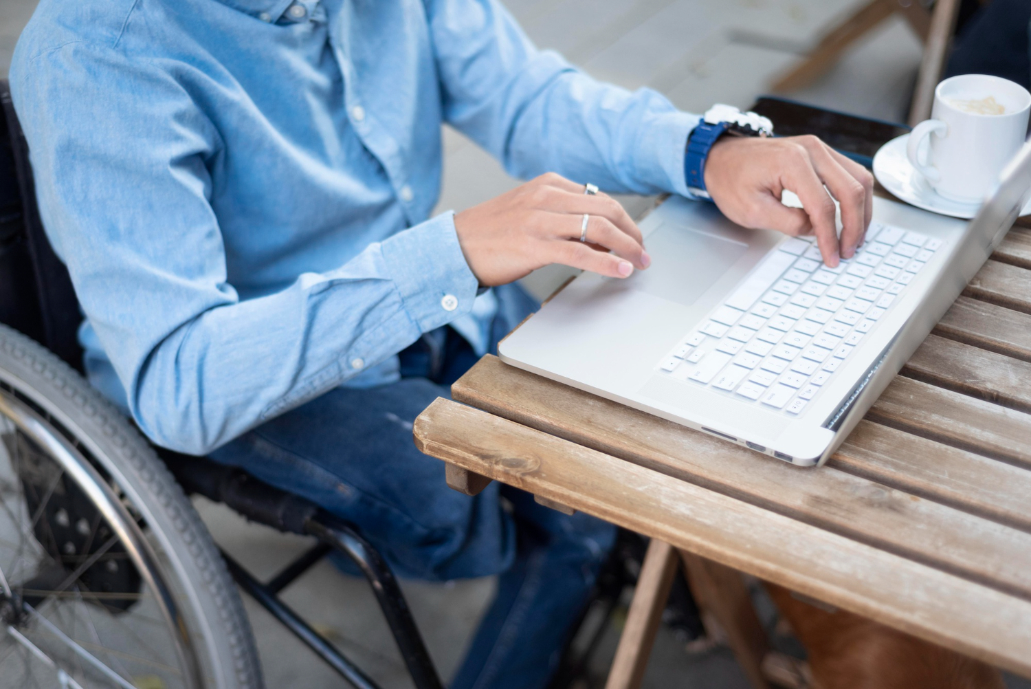 User interacting with accessible digital devices, including a screen reader, braille display, and voice commands.